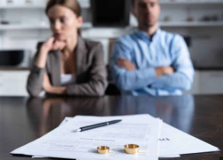 Divorcing couple with wedding rings on legal papers, supported by professional accountants Bolton for financial guidance
